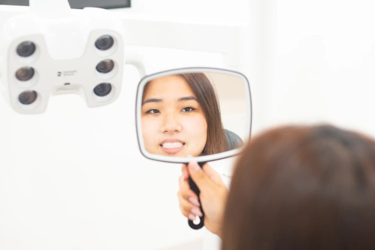 Patient viewing her smile in a mirror during treatment planning