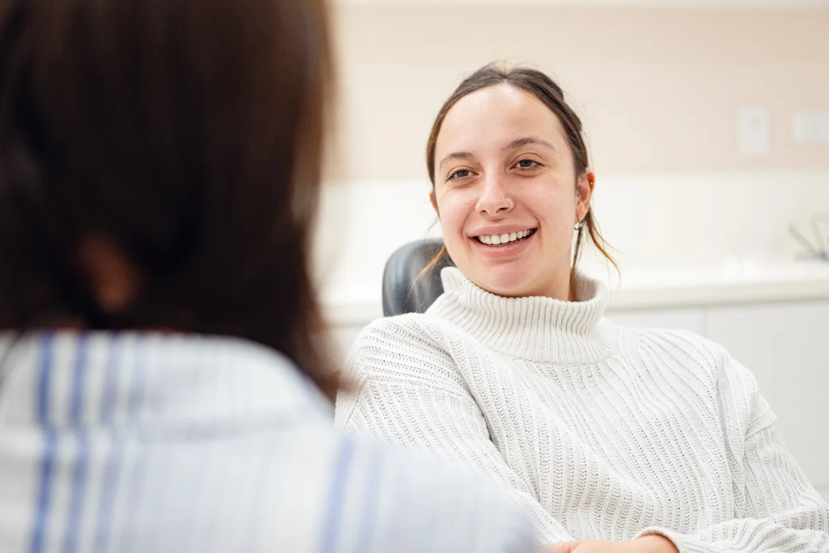 Patient smiling while speaking with her dentist