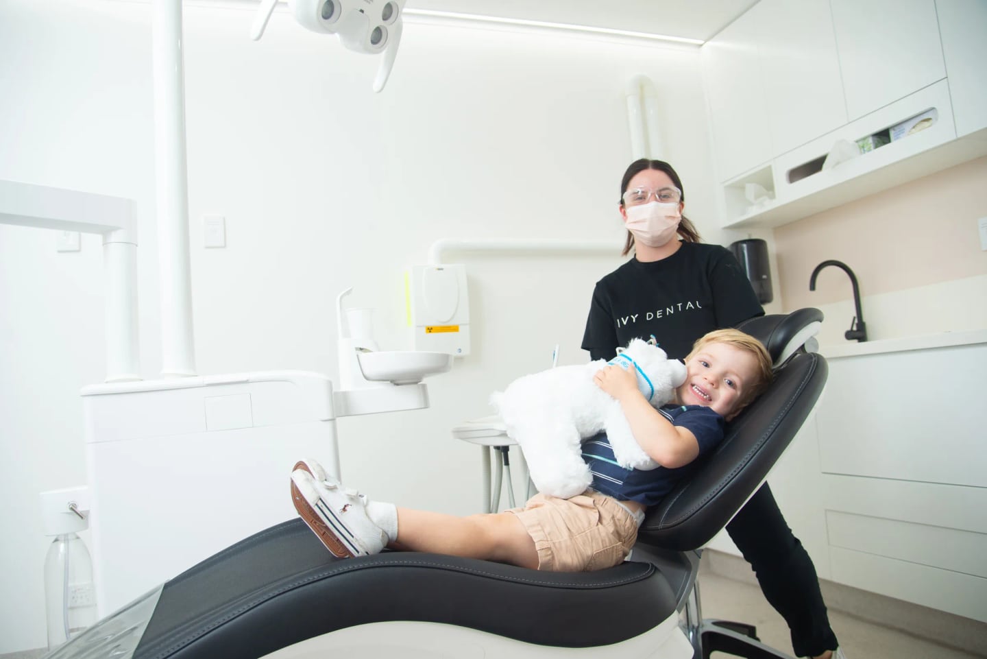 Child smiling in the dental chair with an Ivy Dental clinician