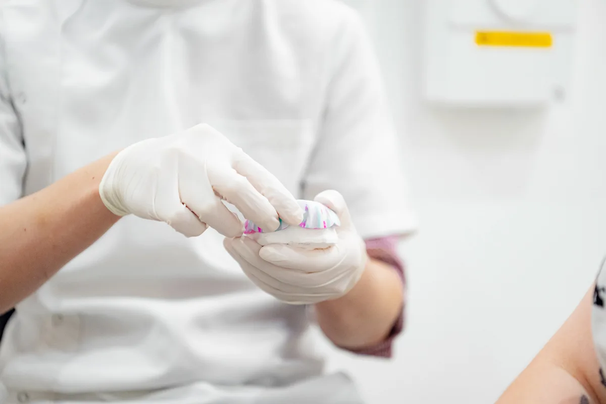 Dentist examining a ceramic crown before placement