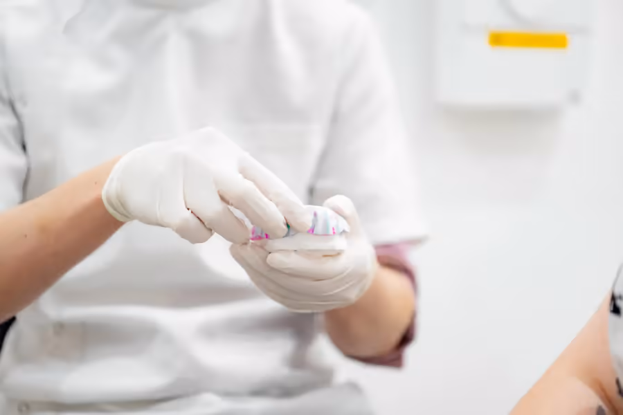 Dentist examining a ceramic crown before placement